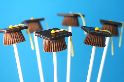 Candy cup graduation caps on a blue background