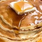 close up of stack of fluffy pancakes with syrup