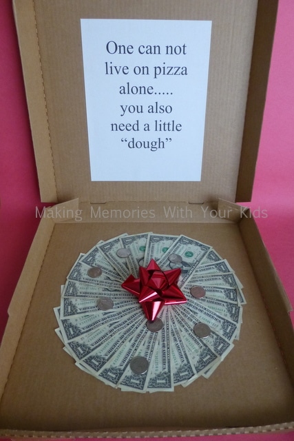 a pizza box with dollar bills and quarters arranged to look like a pepperoni pizza