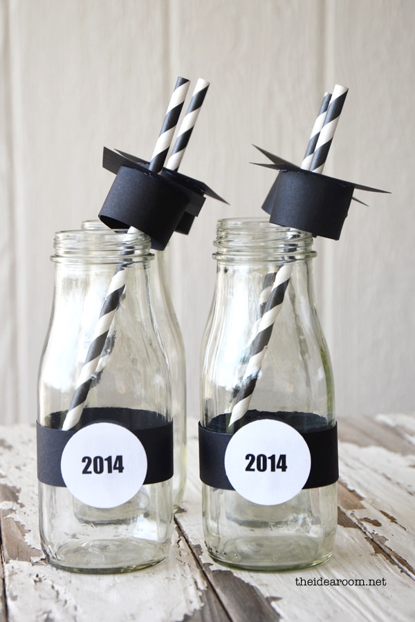 2 glass bottles with graduation hat lids and it says 2014 around the bottle