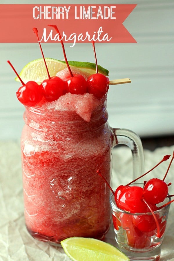 cherry lime aid margarita in a jar glass and a small glass with cherries on the side