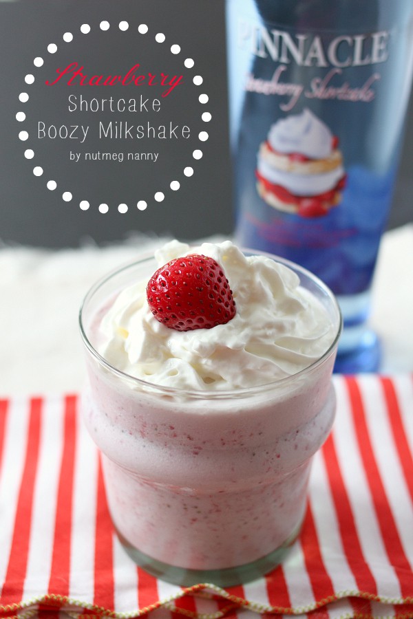 Strawberry shortcake milkshake in a small glass with whipped cream and a strawberry on top