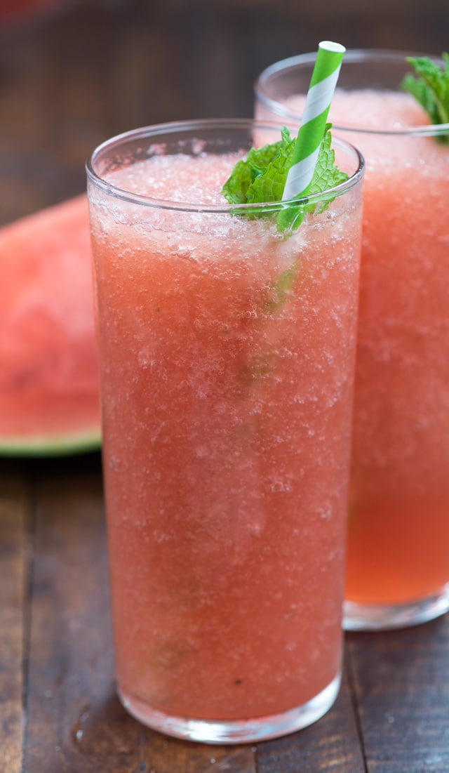 watermelon frose close up in tall glass with a green and white straw