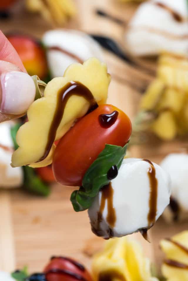 hand holding caprese skewer