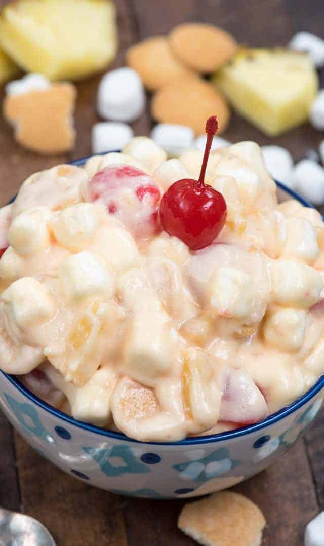 pineapple cake fluff in a blue bowl and a cherry on top