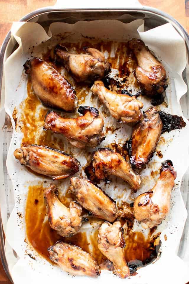 Honey baked chicken wings in baking pan lined with paper