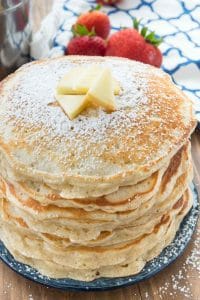 stack of apple fritter pancakes on a blue plate with butter on top