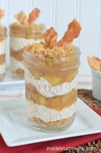 Apple Pie Cheesecake Parfaits  in a jar sitting on a white plate