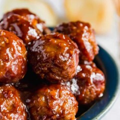 A close up to the side of a bowl of BBQ Meatballs.