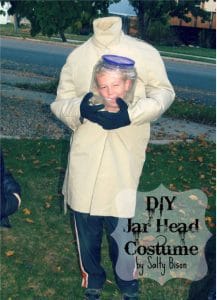 boy dressed in costume showing his head in a jar