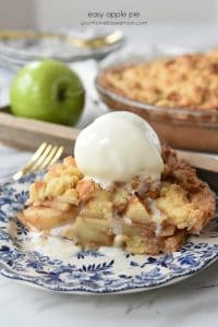 Easy Apple Pie on a blue and white plate with a fork. Ice cream is on top of the pie
