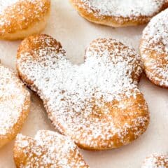 beignets shaped like Mickey Mouse and covered in powdered sugar.