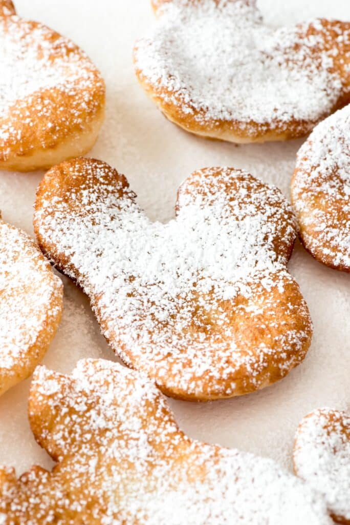 beignets shaped like Mickey Mouse and covered in powdered sugar.