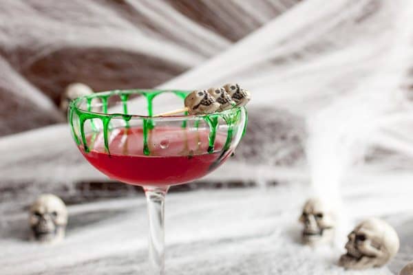 Ta-Kill-A Tequila Vampire Cocktail with small skulls on the rim of the glass and green dripping down the sides