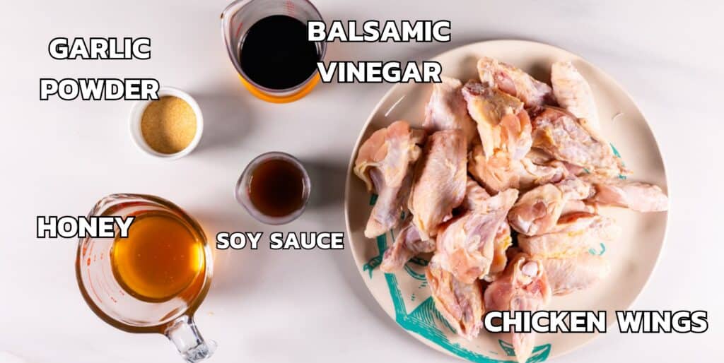 ingredients in honey chicken wings laid out on a white marble counter.