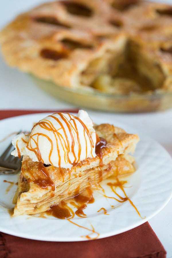 Salted Caramel Apple Pie on a white plate. Ice cream is on top of the pie
