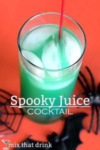 Spooky Juice cocktail which is green in a glass and a red background with spiders and a bat