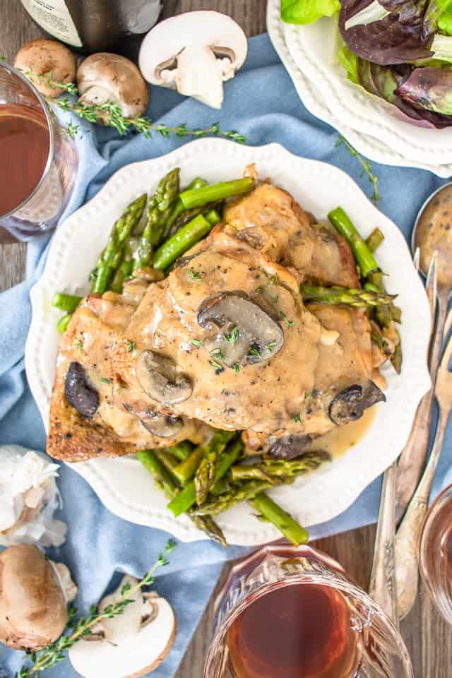 Slow Cooker Chicken Thighs on a white plate with asparagus