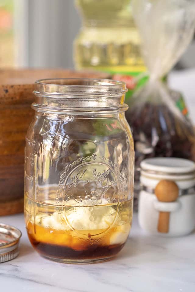 a jar with all the ingredients to make maple vinaigrette 