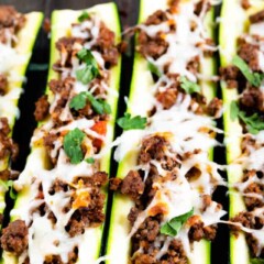 Vertical shot of italian stuffed zucchini boats with herbs in background
