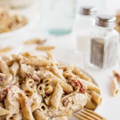 Chicken bacon ranch pasta on a white plate with wood fork