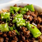 Close up shot of korean beef bowls with green onions and sesame seeds on top