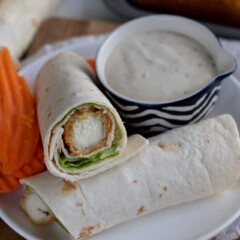 Easy turkey wraps on a white plate with a side of carrots and ranch