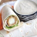 Easy turkey wraps on a white plate with a side of carrots and ranch and recipe title on top