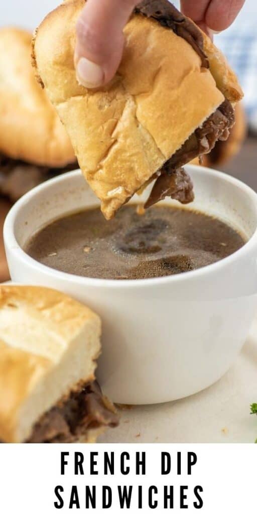 Half of french dip sandwich being dunked into a small dish of au jus with recipe title on bottom of photo