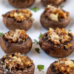 Stuffed mushrooms in two rows on a white serving platter