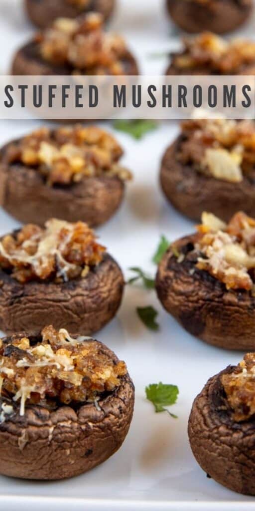 Stuffed mushrooms in two rows on a white serving platter with recipe title in middle of photo