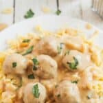 Swedish meatballs on a plate with egg noodles and recipe title on top of image