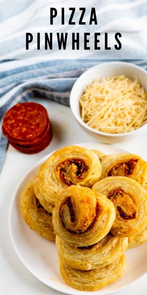 Overhead shot of pizza pinwheels on a plate with cheese and pepperoni next to them and recipe title on top of image