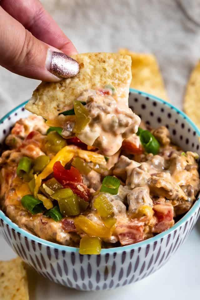 Chip and dip coming out of bowl of sausage queso dip