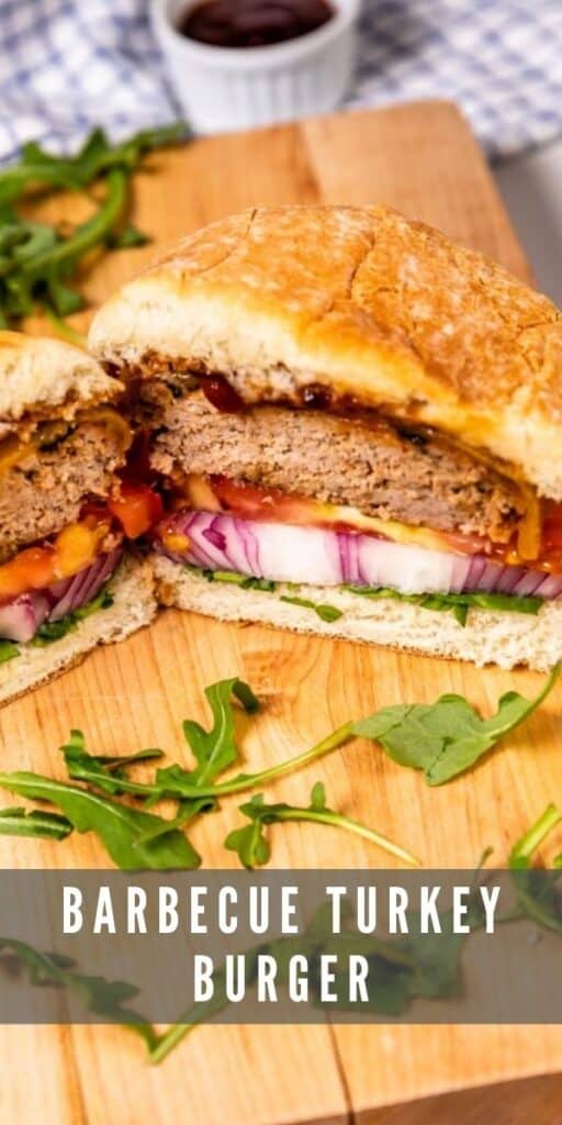 Barbecue turkey burger cut in half on wood cutting board surrounded by arugula with recipe title on bottom of image