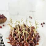 Plate of cocktail meatballs with toothpicks sticking out of top