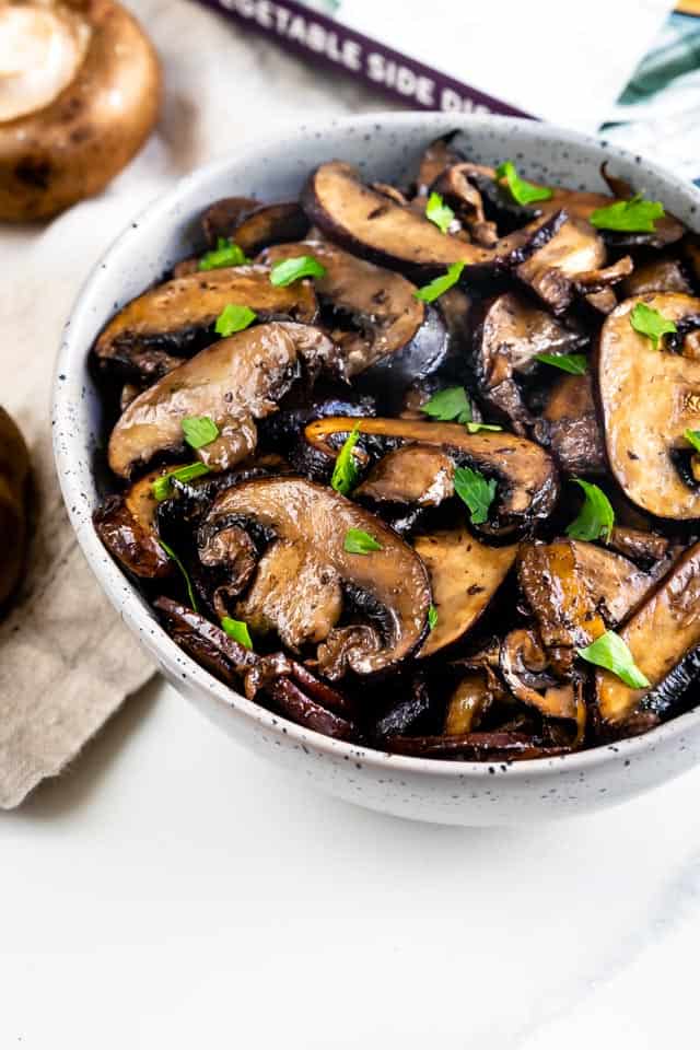 Overhead shot of oven seared mushrooms in a white serving bowl