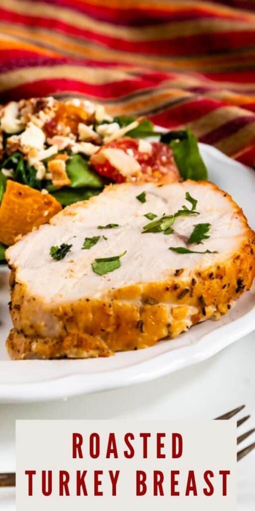Close up shot of a slice of roasted turkey breast on a white plate with salad and a fork and recipe title on bottom of image