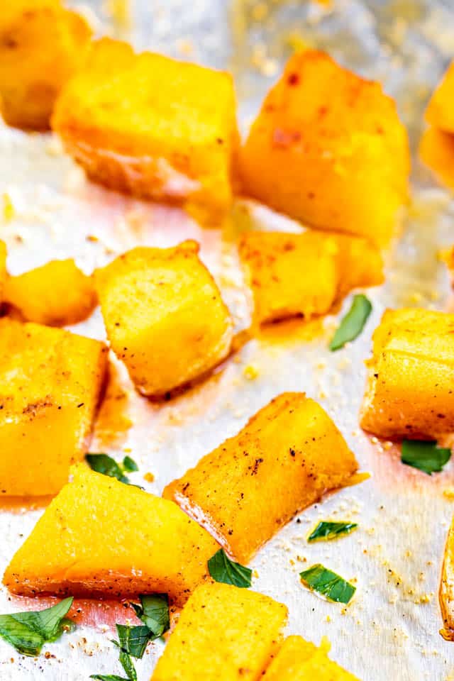 Close up shot of cubed butternut squash on a sheet pan covered in foil