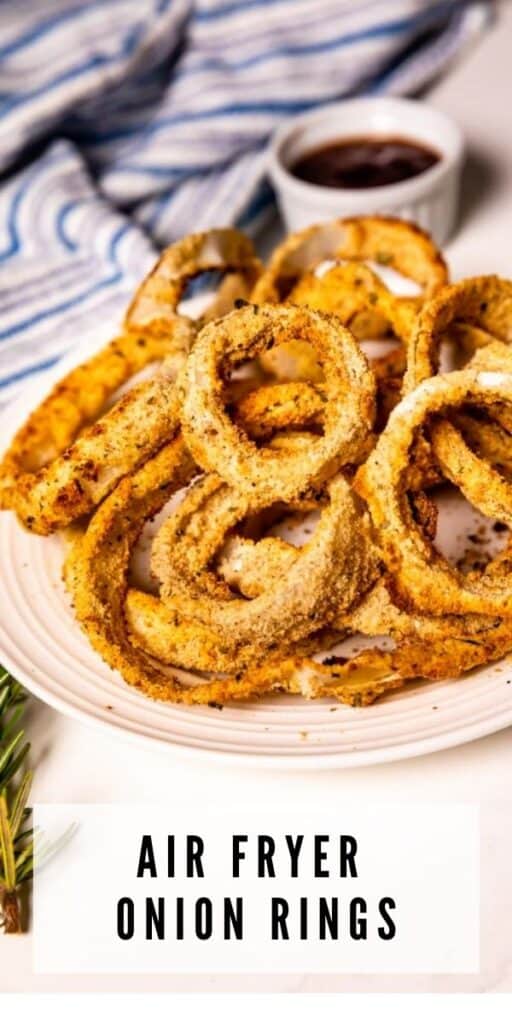 Air fryer onion rings on a white plate with dipping sauce on the side and recipe title on bottom of photo