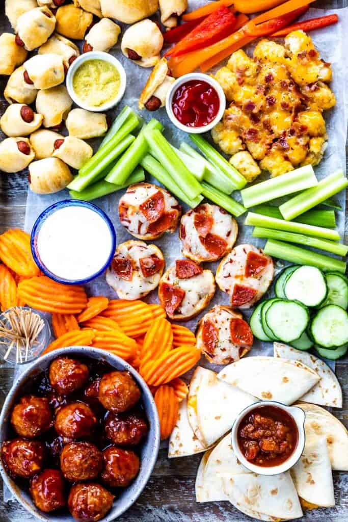 Overhead view of appetizer board filled with different appetizers and snacks