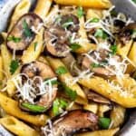 Overhead shot of mushroom pasta in a bowl with recipe title on top of image
