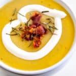 Overhead close up of potato leek soup topped with bacon and sour cream