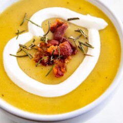 Overhead close up of potato leek soup topped with bacon and sour cream