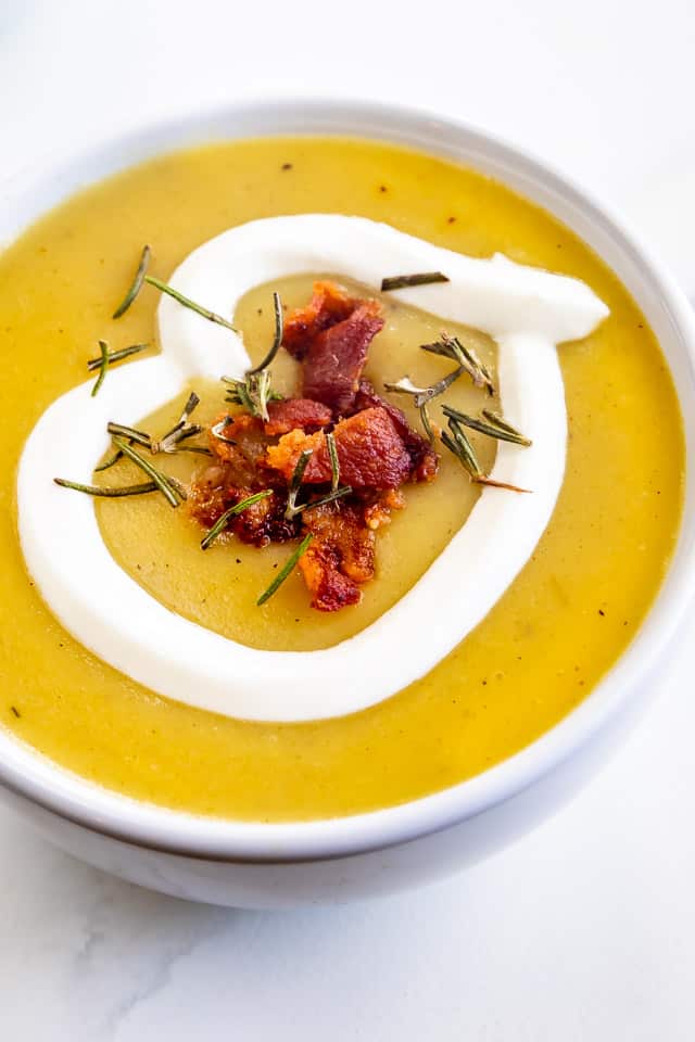 Overhead close up of potato leek soup topped with bacon and sour cream