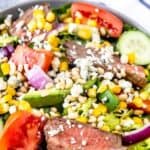 Overhead shot of steak salad in large bowl with recipe title in top right hand corner of photo