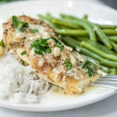 Close up side shot of chicken in garlic sauce plated with green beans and white rice