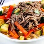 Crockpot flank steak on a plate with veggies