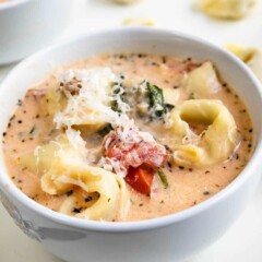 Bowl of crockpot tortellini soup with shaved parmesan on top