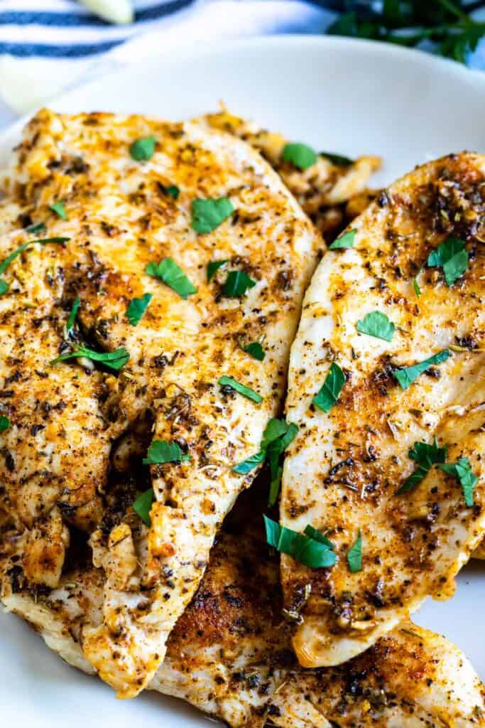 Close up shot of garlic butter chicken breasts on white plate